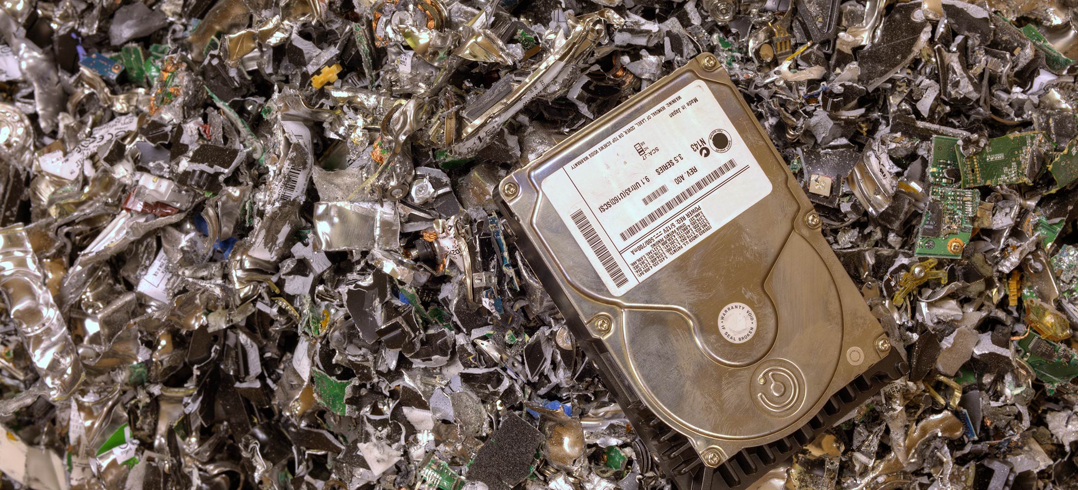 hard drive on top of a pile of hard drive destruction shreds